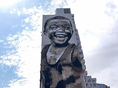 Неподалік від метро Палац України, на вулиці Казимира Малевича, на стіні будинку, розташований величезний мурал із зображенням чорношкірого хлопчика, що розплився в безтурботній посмішці.